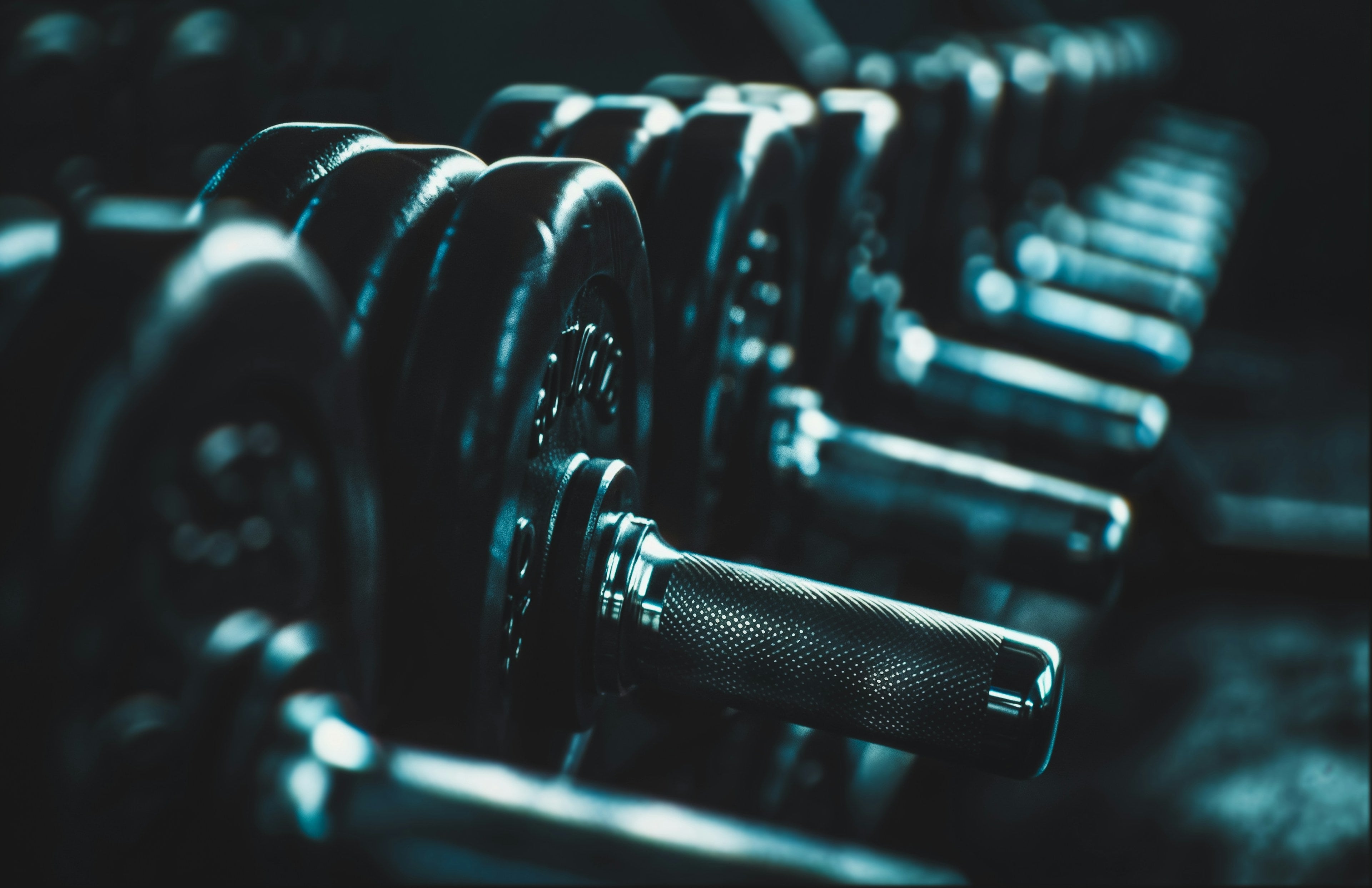 A trainee lifting a loaded barbell off the gym floor